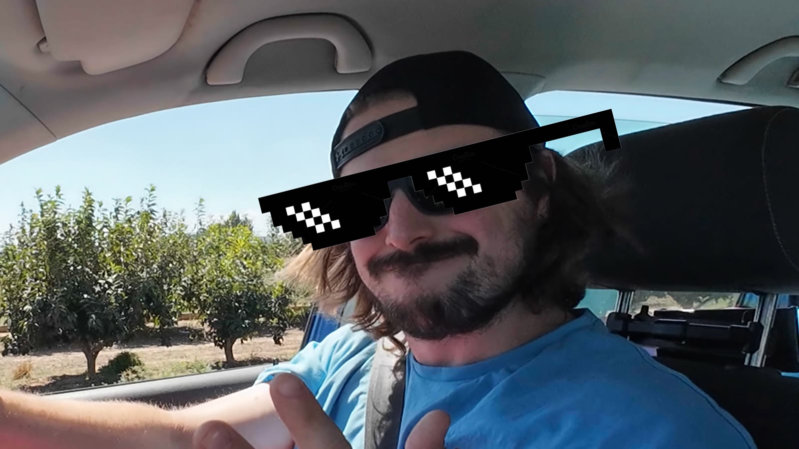 A selfie from the passenger seat, pixel sunglasses added