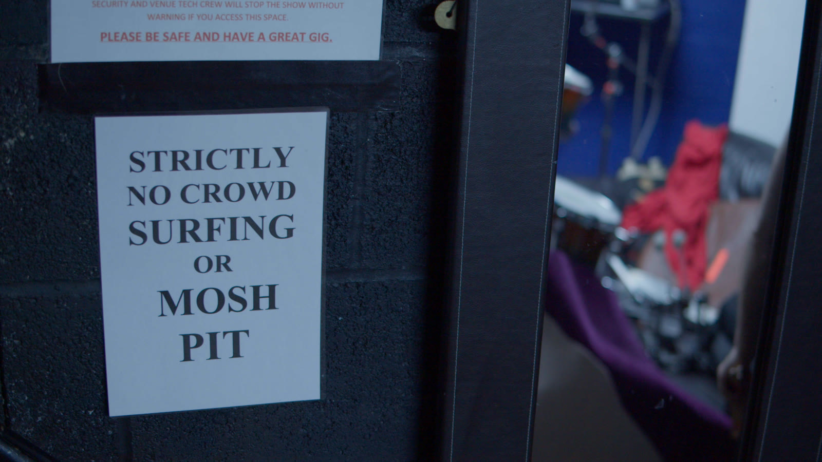 A sign backstage reading strictly no crowd surfing or mosh pit